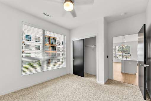 A room with a black door and a window with blinds.