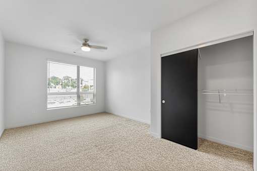 A room with a black door and a ceiling fan.