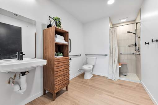 A bathroom with a wooden cabinet and a white sink.