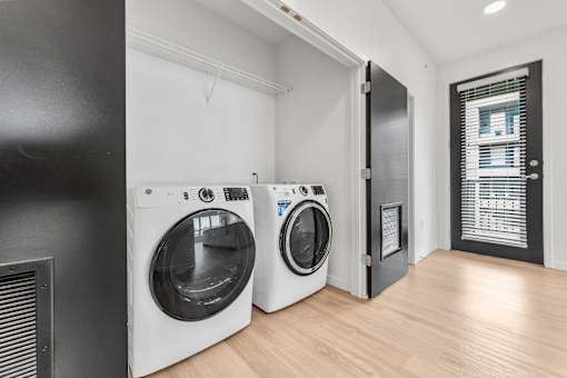 Two front load washing machines in a laundry room.