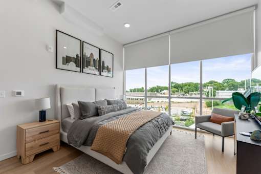 A bedroom with a large bed and a view of the outside.