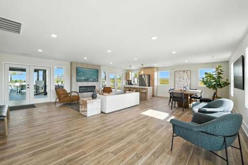 A modern living room with a grey armchair and a white sofa.