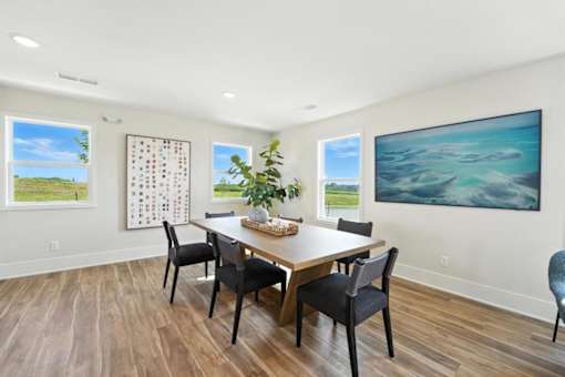 A dining room with a wooden table and chairs.
