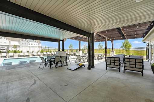 A patio with a table and chairs is covered by a roof.