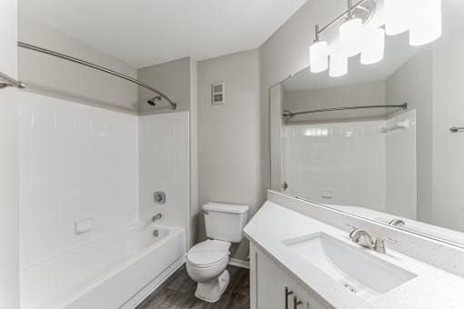 A white bathroom with a toilet, sink, and bathtub.