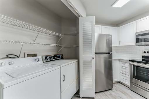 A modern kitchen with stainless steel appliances and white cabinetry.