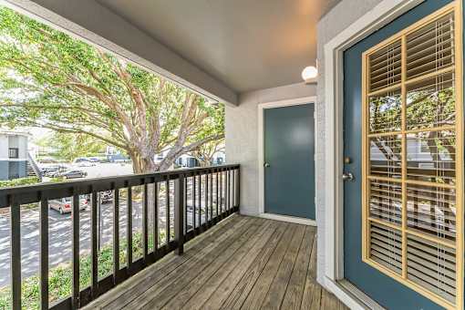 A balcony with a black railing and a blue door.
