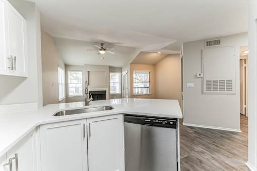 A kitchen with white cabinets and a stainless steel dishwasher.