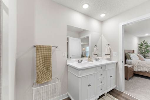 A white bathroom with a vanity and a mirror.