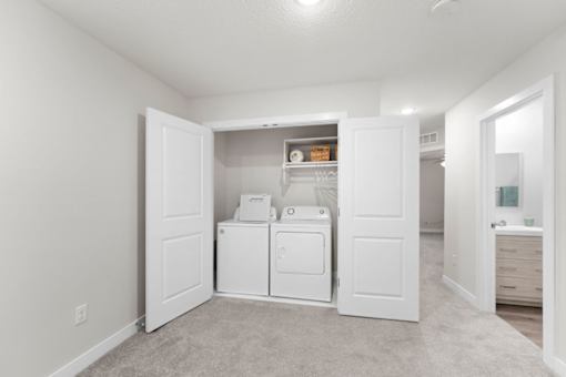 A white laundry room with a washer and dryer.