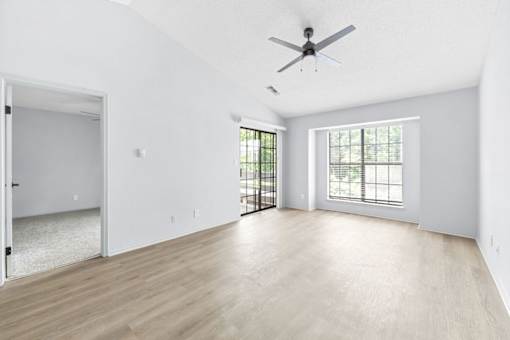 A spacious room with a ceiling fan and sliding glass doors.