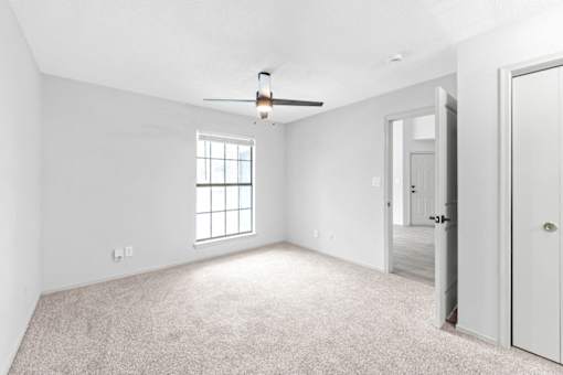 A room with a ceiling fan and a window.