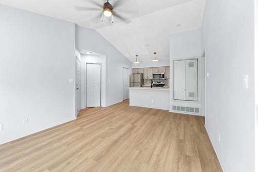 A room with a ceiling fan and wooden flooring.