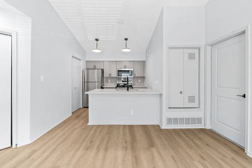 A kitchen with white cabinets and a white island.