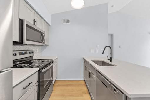 A modern kitchen with stainless steel appliances and white cabinets.