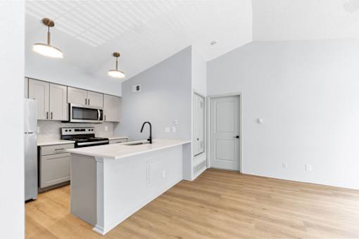 A kitchen with a white counter top and a stove top oven.