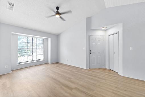 A room with a ceiling fan and two doors.