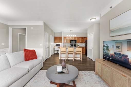 A living room with a grey couch and a television on a wooden stand.