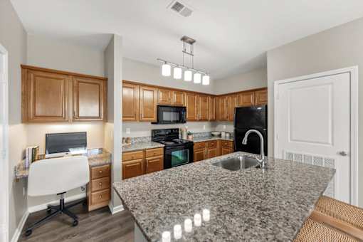 A kitchen with granite countertops and wooden cabinets.