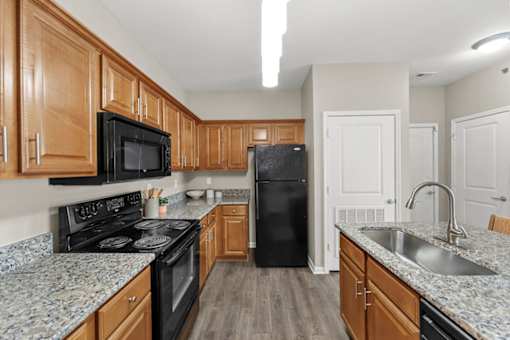 A kitchen with wooden cabinets and black appliances.