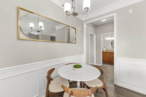 A dining room with a white table and chairs.