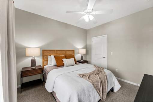 A bedroom with two beds and a ceiling fan.