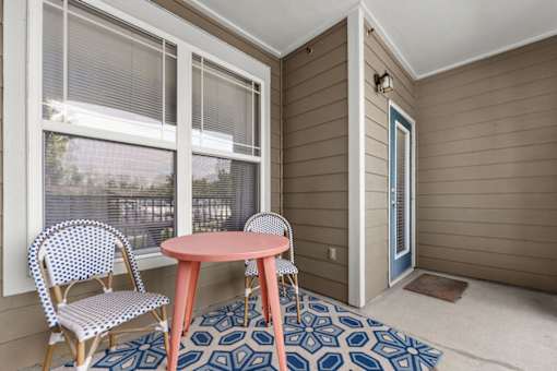 A patio with a table and chairs.
