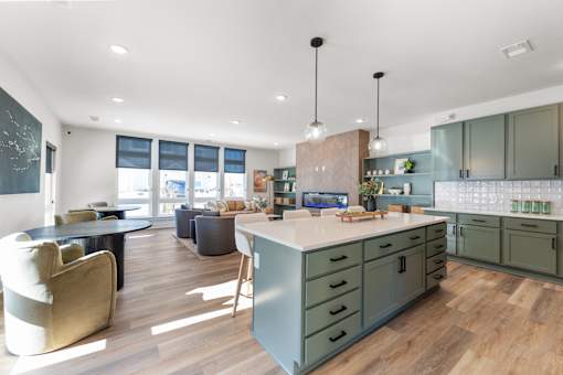 A modern kitchen with a large island and pendant lights.