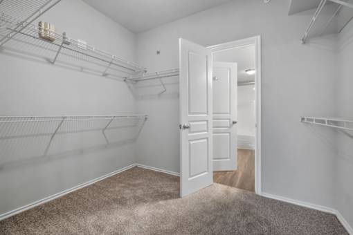 A room with a carpeted floor and a white door.
