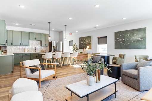 A modern living room with a kitchen area in the background.