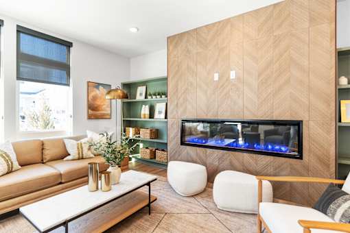 A modern living room with a fireplace and a large painting on the wall.