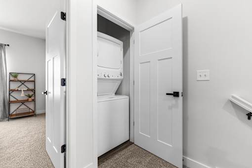 A white kitchen with a white fridge and white cupboard.