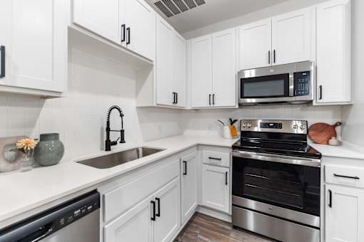 A kitchen with white cabinets and stainless steel appliances.