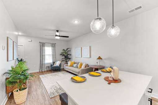 A living room with a couch, a table, and a plant.