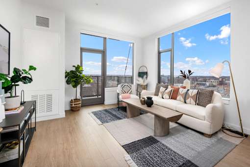 A living room with a large window and a view of the city.