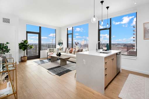 A modern kitchen with a large island and a view of the city.