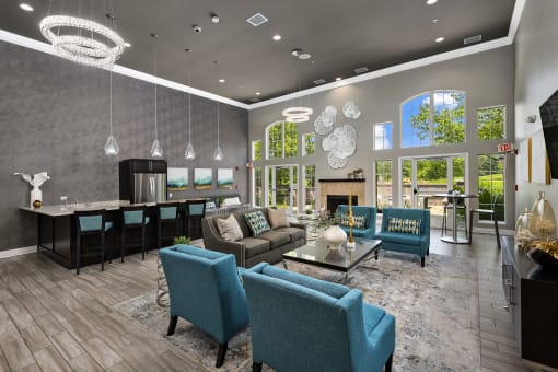 a living room with couches and chairs and a kitchen with a fireplace