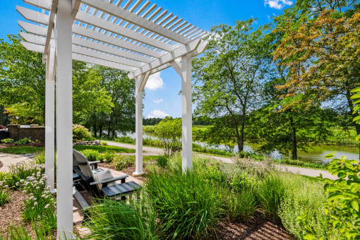 a pergola with a picnic table in a garden