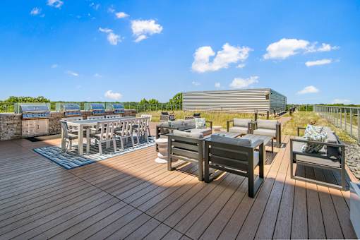 A wooden deck with a table and chairs overlooking a field.