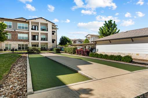 Apartment complex with a green lawn and a small putting green.