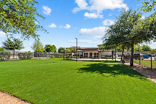 A large grassy field with a building in the background.