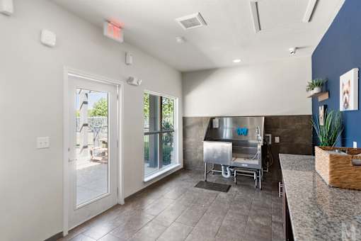A kitchen area with a stainless steel sink and a window with a view of the backyard.