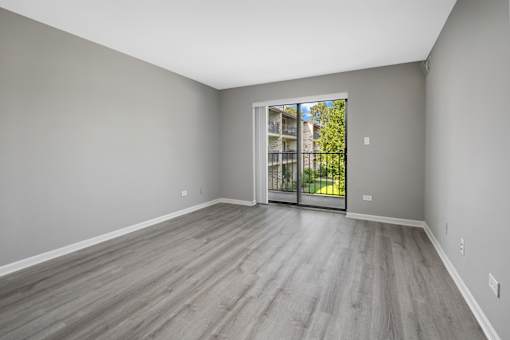 A room with a sliding glass door leading to a balcony.
