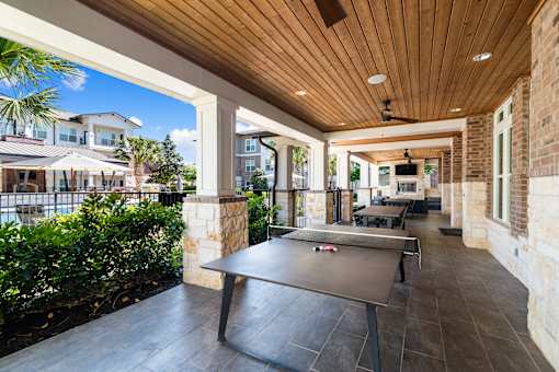 A black table is in the middle of a patio.