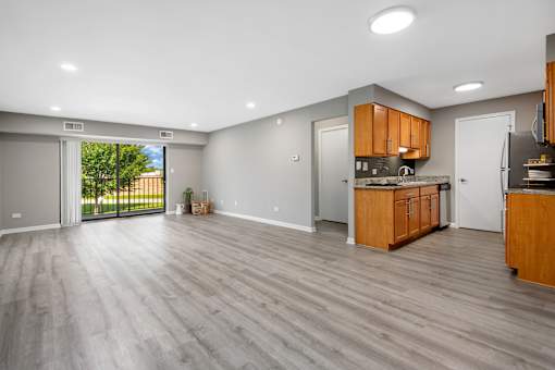 A spacious kitchen with wooden cabinets and a marble countertop.