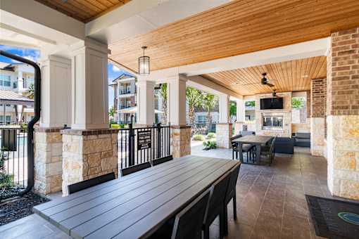 A wooden table is in the middle of a patio.