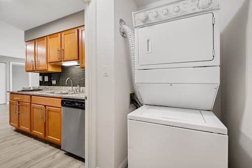 A white dryer is sitting next to a white washer in a small laundry room.