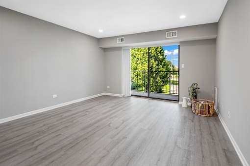 A room with a sliding glass door leading to a green outdoor area.