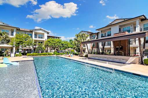 A swimming pool in front of a row of houses.