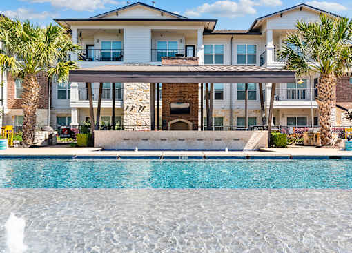 A large house with a pool in front.